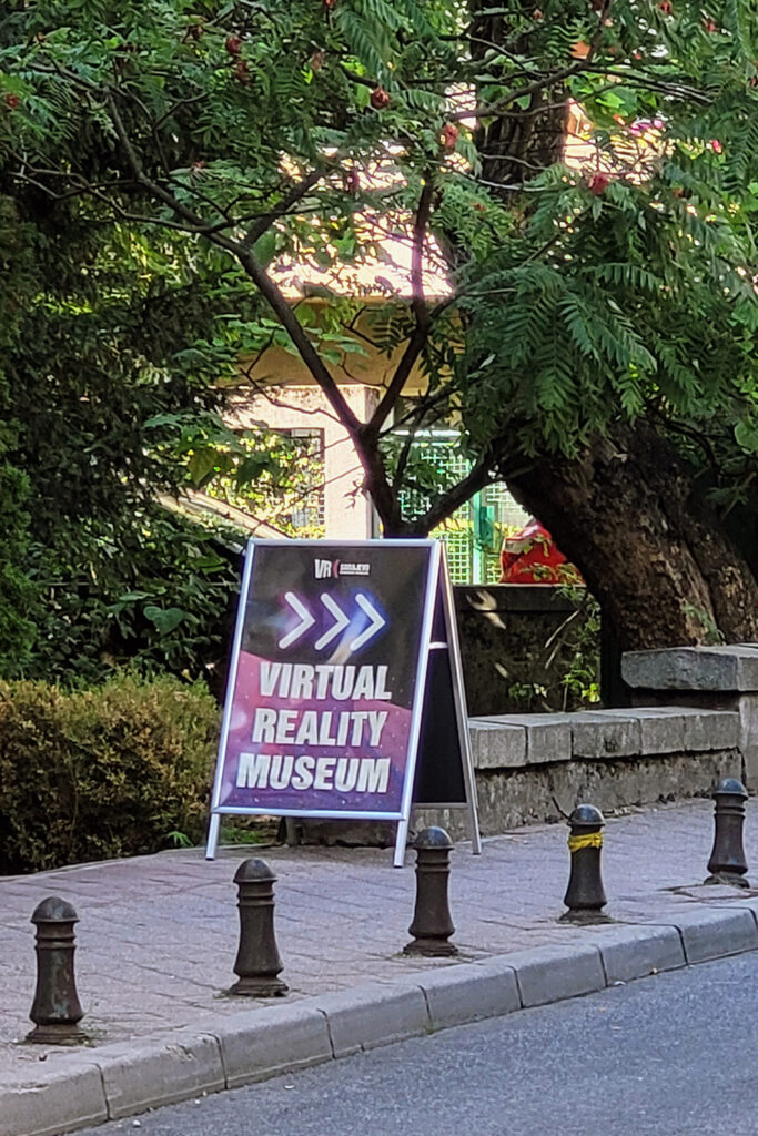Hinweisschild zum VRX Museum. Der Eingang ist leicht zu übersehen. - City-Check Sarajevo, FemNews.de Ein Hinweisschild zeigt den Weg zum VRX Museum in Sarajevo.