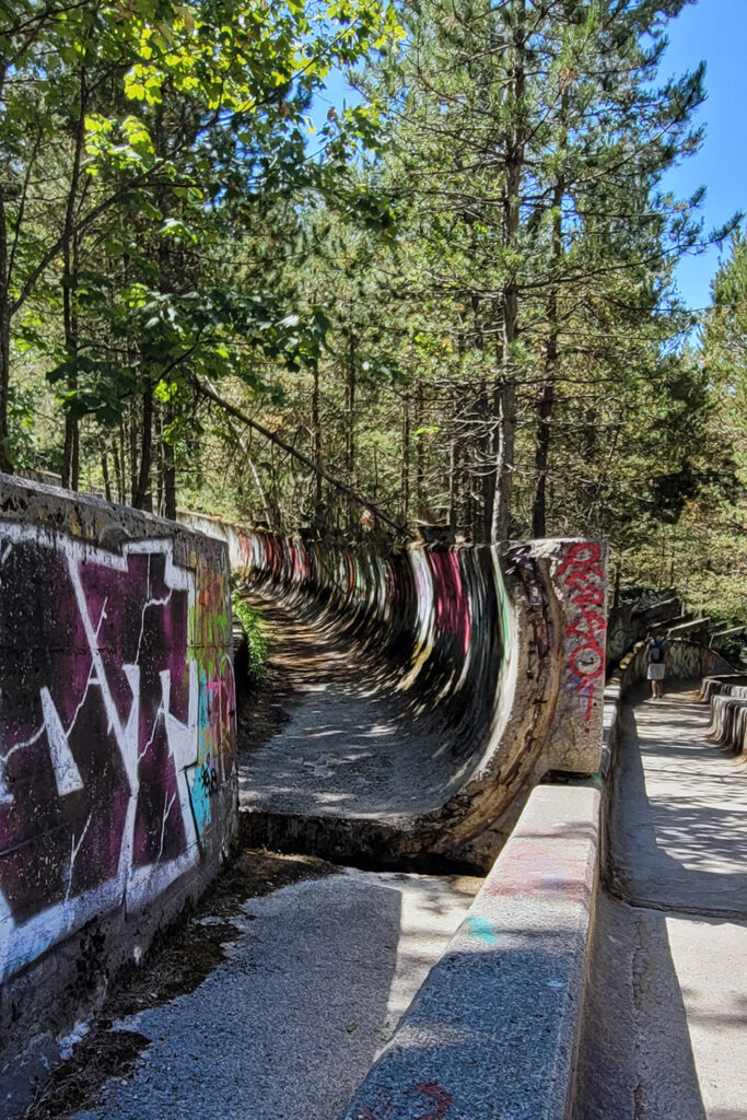 Die ehemalige Olympia-Bobbahn verläuft durch den Wald auf dem Trebević. Die Natur erobert sich die Strecke zurück. - City-Check Sarajevo, FemNews.de Mit Graffiti bemalte Betonkurve der Olympia-Bobbahn auf dem Trebević