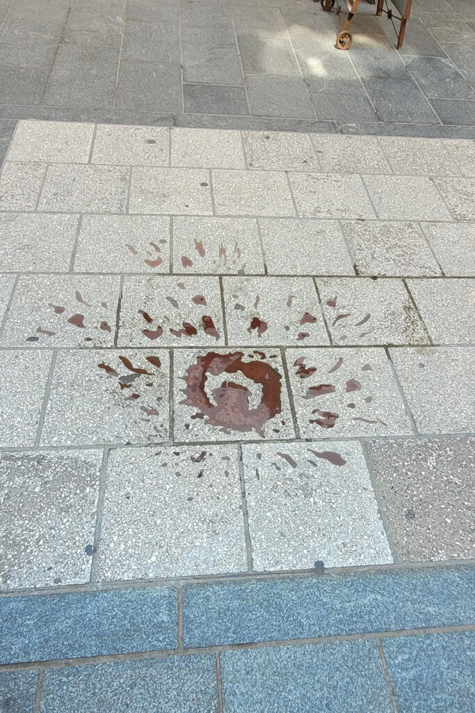 Sarajevo-Rose: mit rotem Harz gefüllte Einschlagstelle im Asphalt. - City-Check Sarajevo, FemNews.de Sarajevo-Rose in der Altstadt